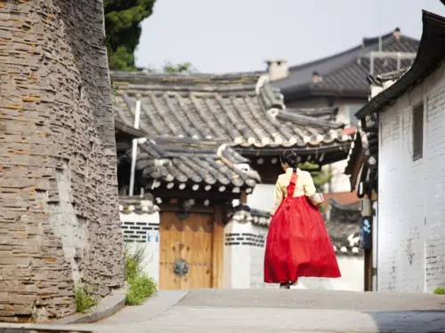 Lady in a red dress walking through Bukchon Hanok Village