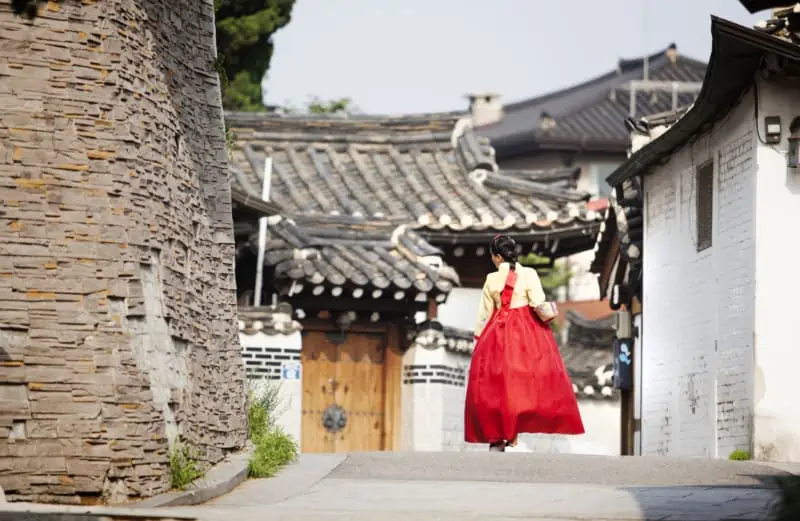 Lady in a red dress walking through Bukchon Hanok Village