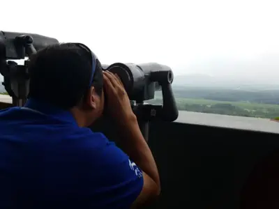 A man looking at North Korea from Dora Observatory using high powered binoculars