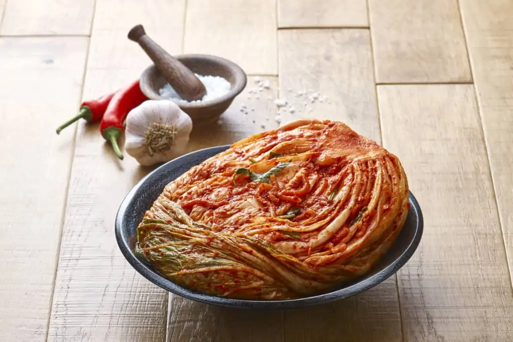 Making Kimchi by adding salt, garlic and chilli