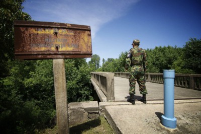 A soldier standing guard in front of the Bridge of No Return facing North