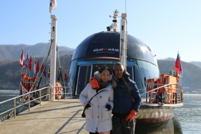 A couple having a photo taken in front of the ferry to Nami Island ferry