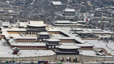 A view of Gyeongbok Palace from above covered in white snow during winter in Seoul