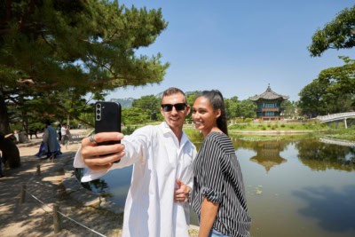 Tourists taking a selfie in front of Hyangwonjeong Pavilion at Gyeongbok Palace in Seoul