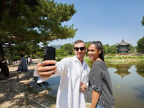 Tourists taking a selfie in front of Hyangwonjeong Pavilion at Gyeongbok Palace in Seoul