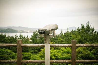 An observation deck with a pair of high-powered binoculars on the peak of one of Jeju's mountains