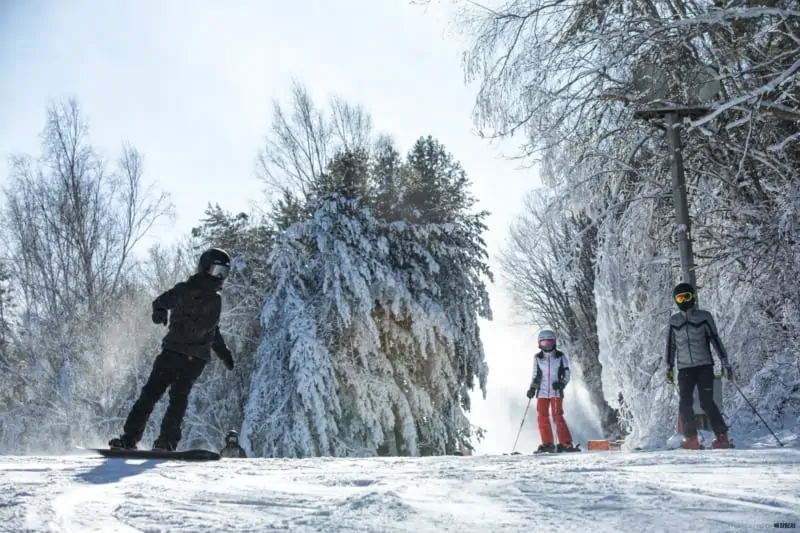 Beginners learning how to ski and snowboard in winter