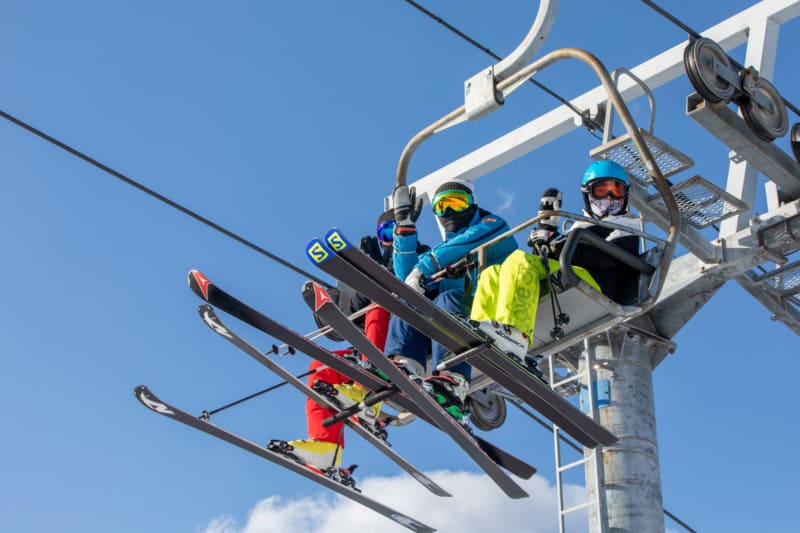 People riding a ski lift to the top of the mountain