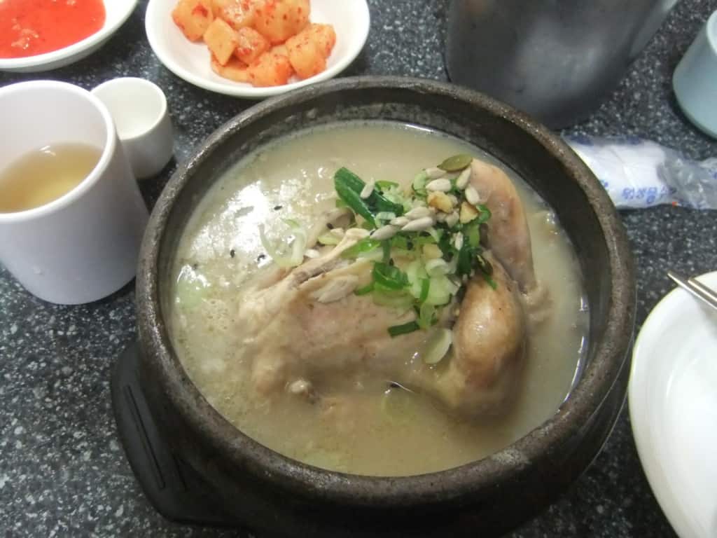 A bowl of delicious Samgyetang plated beautifully with garnish at Tosokchon