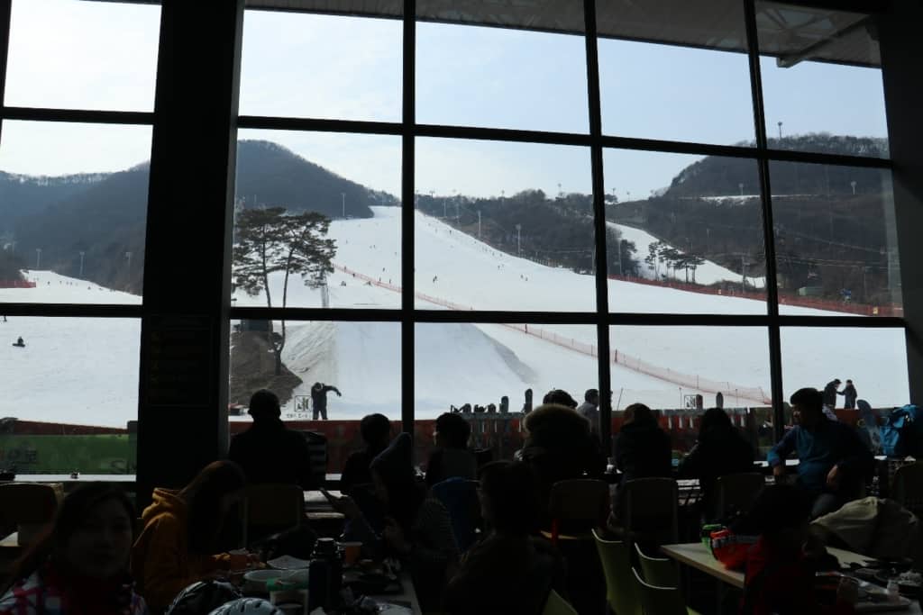 Watching the ski slopes through a large glass window from inside the food hall