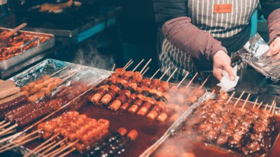 Delicious dakkochi chicken skewers sitting sweet and spicy red sauce ready to be cooked on the grill in Myeong-dong food street