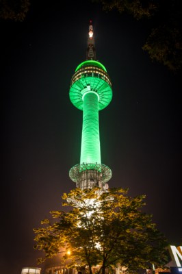 North Seoul Tower with green lighting being projected on to it at night