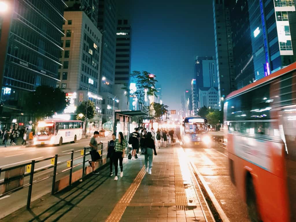 Watching people and buses go by outside the busy Gangnam Station