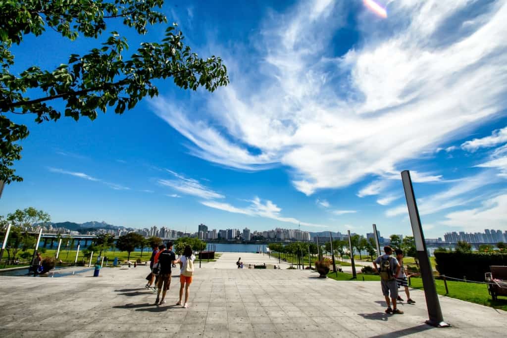 At the entrance of Yeouido Hangang Park on a clear bright day with the Han River in the background