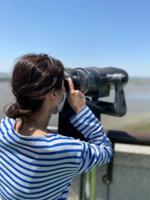 A woman looking into North Korea through binoculars from Mt Odu Unification Observatory