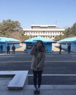 VIP Travel's manager Sue standing in front of the Panmungak and blue UNCMAC conference buildings