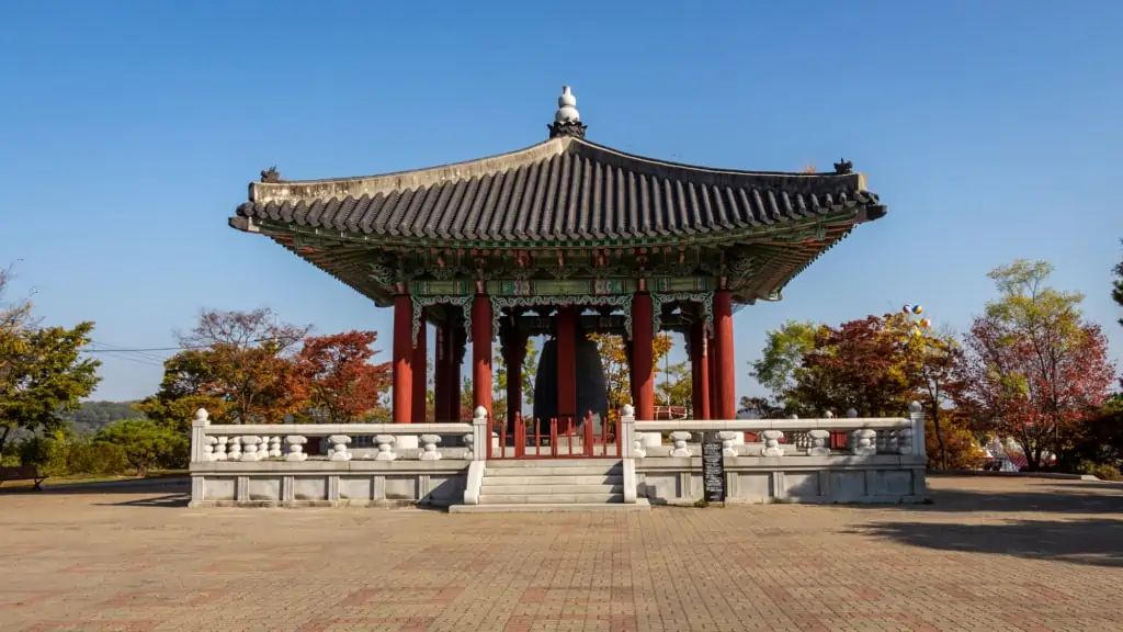 A photo of the Bell of Peace at Imjingak taken during Autumn with colourful trees in the background